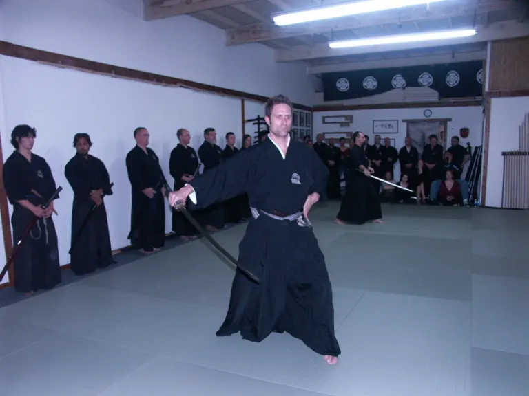 Iaido practitioners performing sword-drawing kata in a dojo