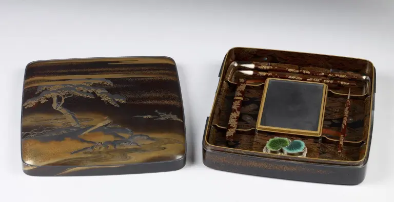 Open Japanese writing box containing an inkstone, brushes, water dropper, stylus, and paper knife