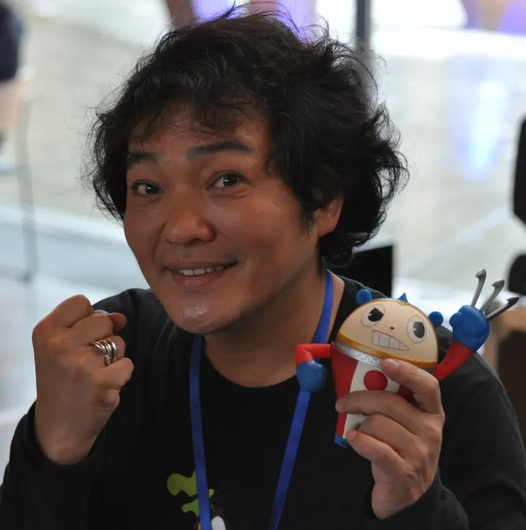 Japanese voice actor Kappei Yamaguchi holding a character figurine at a convention