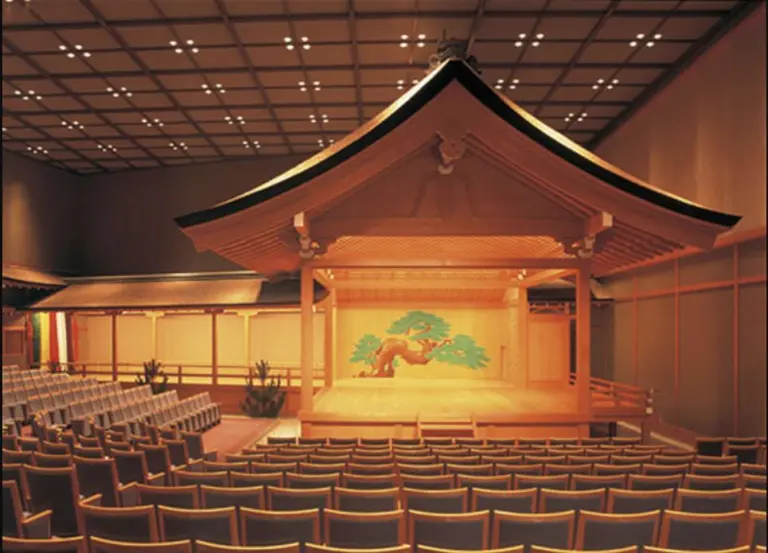 Wooden Noh stage with a painted pine backdrop and bridgeway