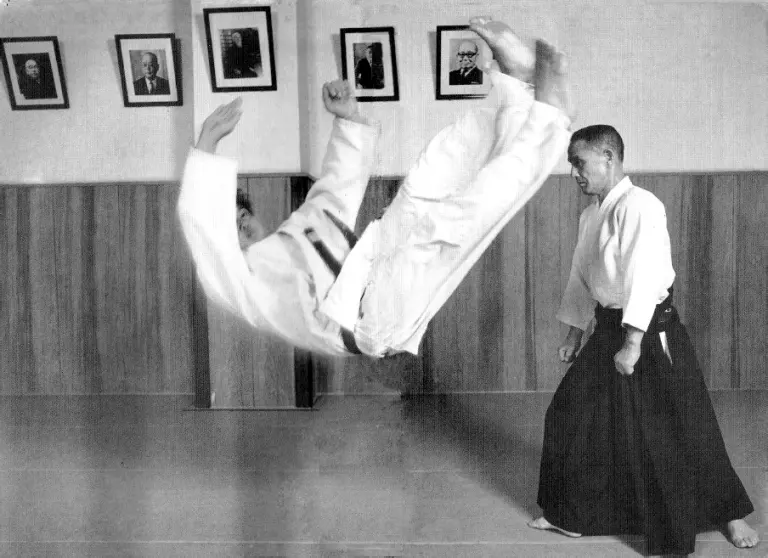 Gozo Shioda in a hakama demonstrating a throw with a training partner