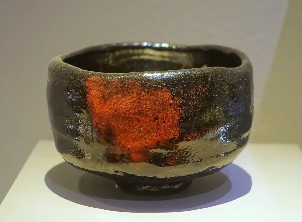 Black-glazed Raku tea bowl with an irregular hand-shaped profile