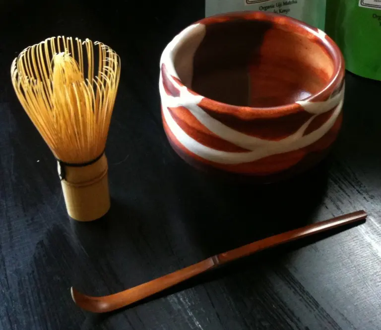 Tea bowl, bamboo whisk, and tea scoop arranged as a matcha set