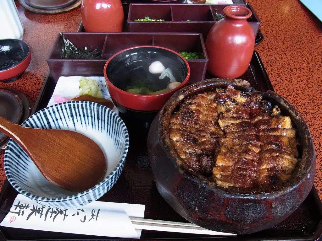 A hitsumabushi meal with grilled eel on rice and accompaniments.