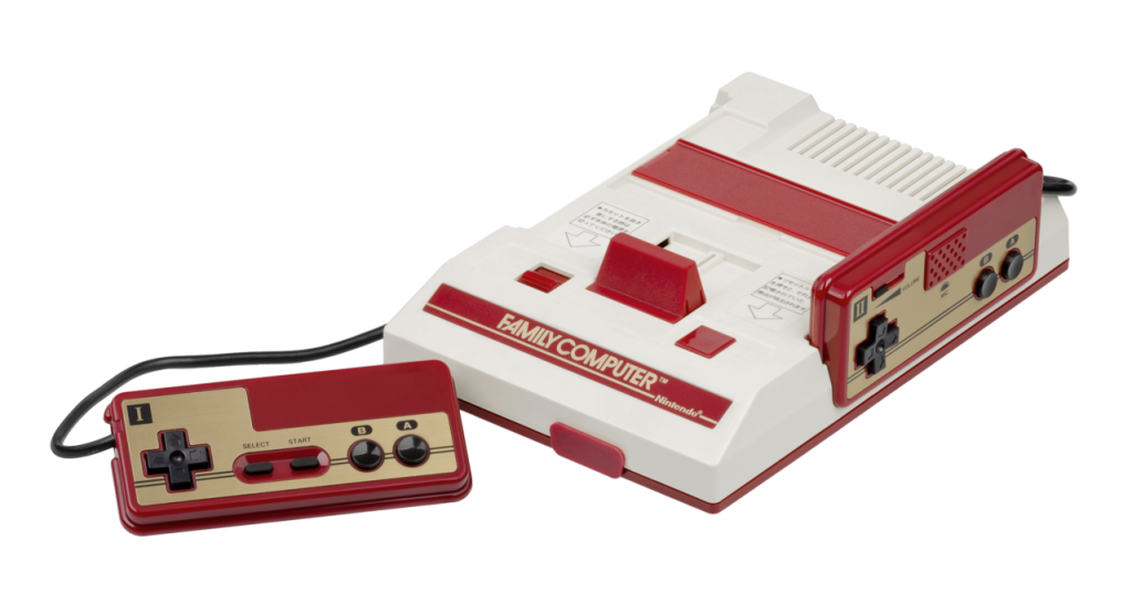 A Nintendo Famicom console with two red-and-gold wired controllers.
