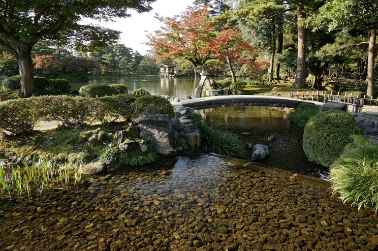 Kasumigaike Pond, stone lanterns, and autumn trees in Kenrokuen garden in Kanazawa