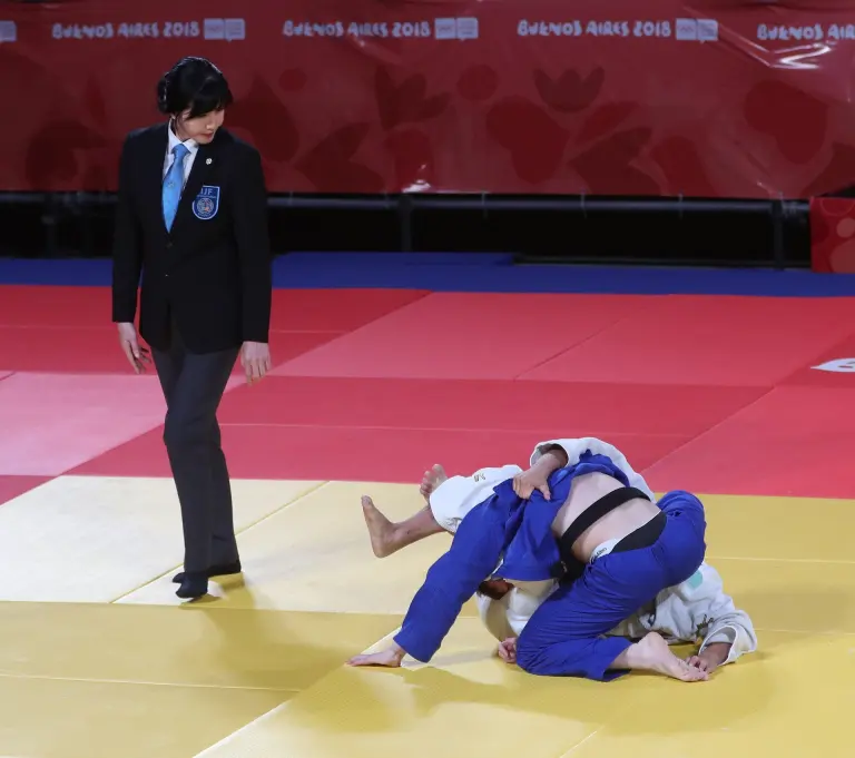 A referee watches a Judo contest at the 2018 Summer Youth Olympics