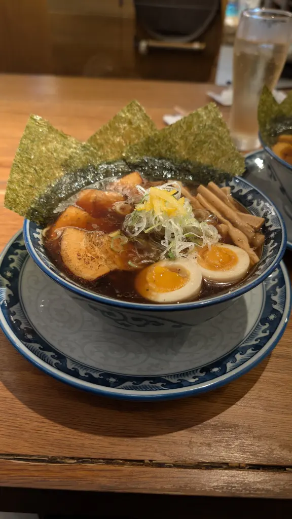 Bowl of ramen in Osaka topped with sliced egg, pork, seaweed, and green onion