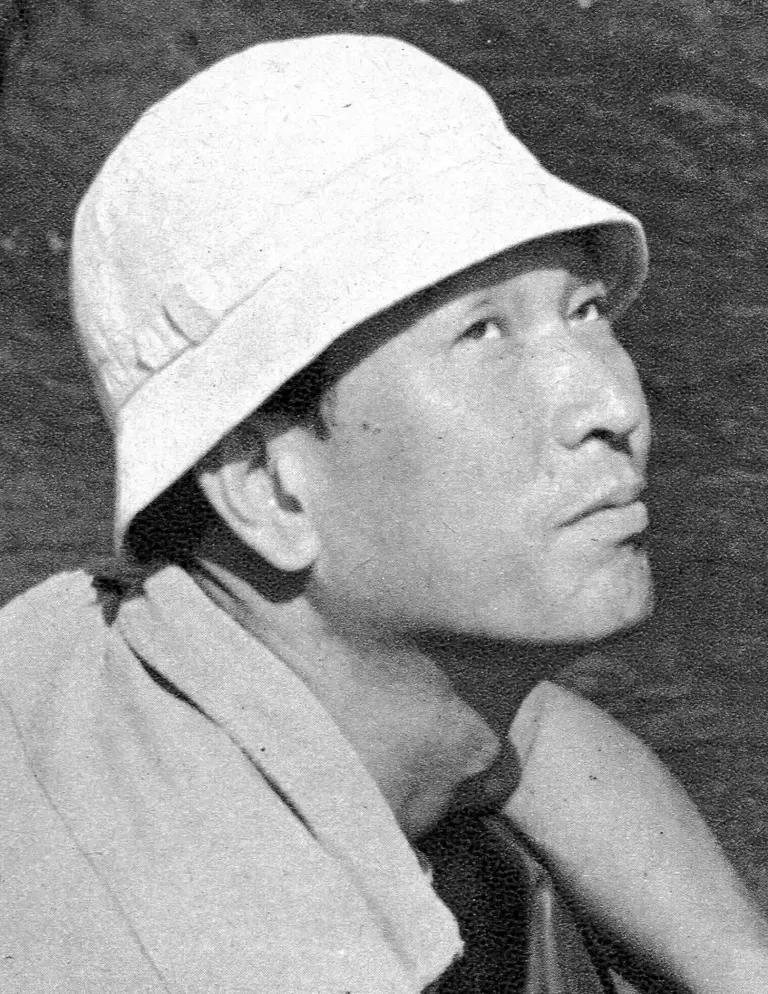 Akira Kurosawa wearing a cap and glasses on a film set.