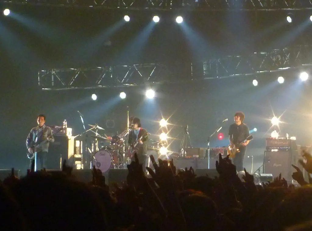 Asian Kung-Fu Generation performing on stage at Countdown Japan with audience hands in the foreground