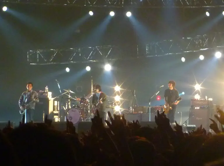 Asian Kung-Fu Generation performing on stage at Countdown Japan with audience hands in the foreground