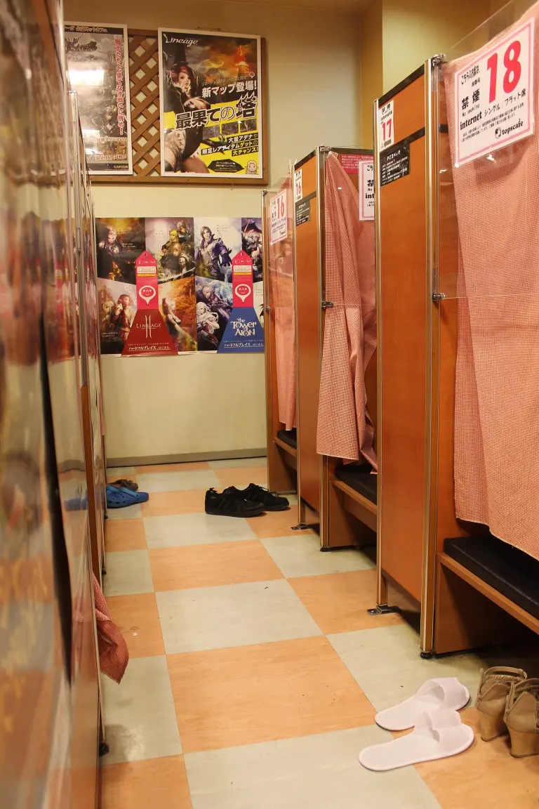 Narrow numbered booth with a computer inside a Japanese internet and manga cafe