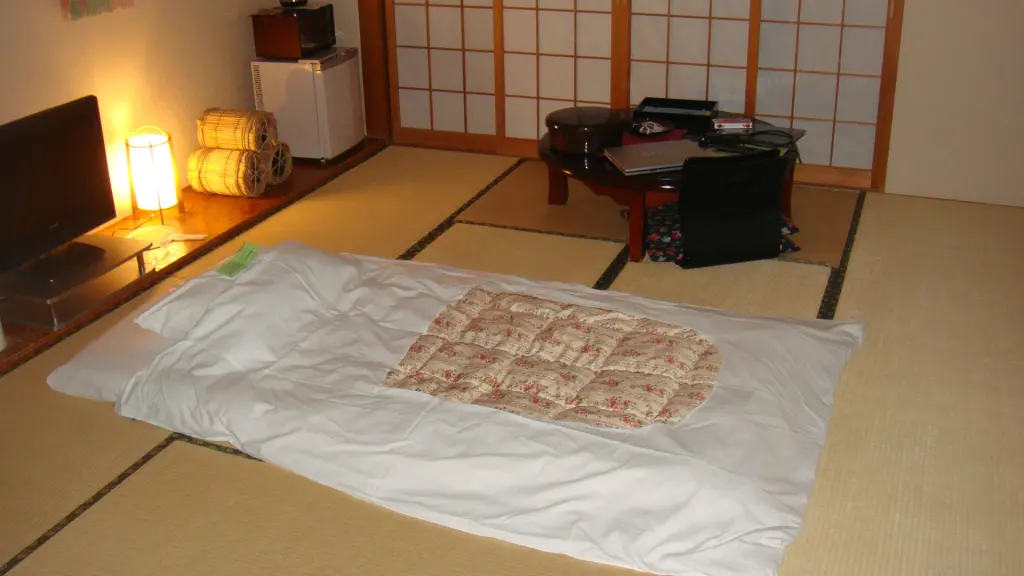 Futon bedding arranged on tatami beside a low table in a ryokan room