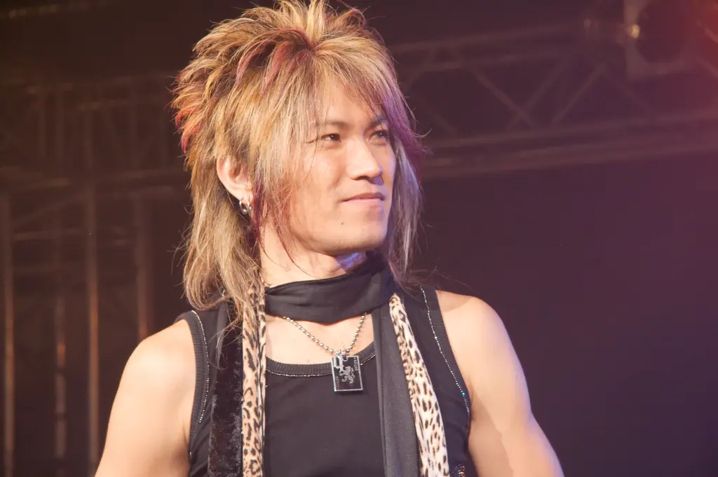 JAM Project perform with microphones and raised arms on a concert stage at Chibi Japan Expo in Paris