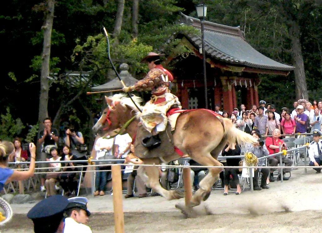 Mounted yabusame archer drawing a long Japanese bow at Tsurugaoka Hachimangu