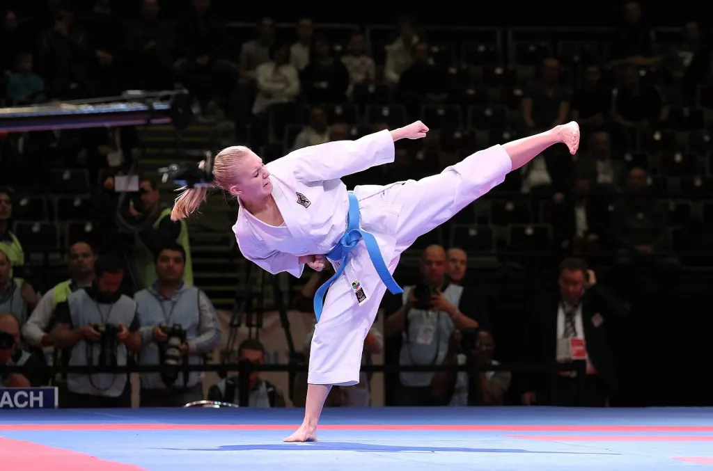 Karate kata competitor balancing on one leg while extending a side kick