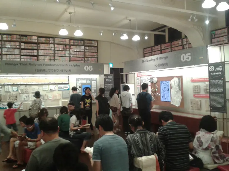 Visitors and manga shelves in the main hall of Kyoto International Manga Museum