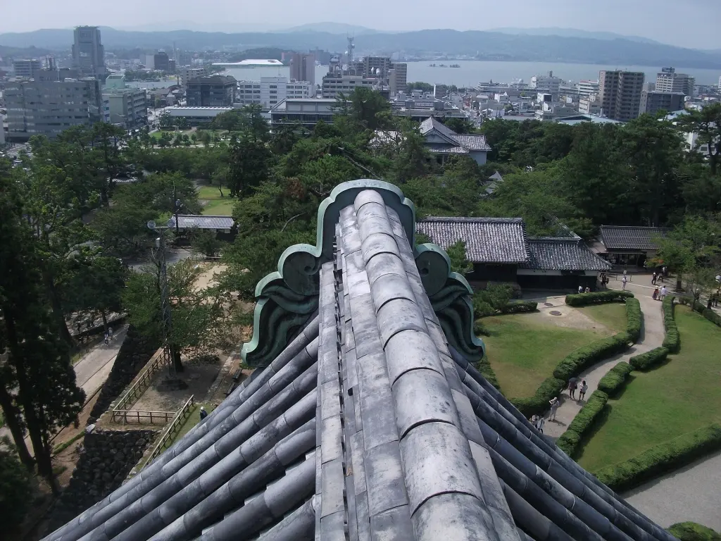 Matsue Castle keep above trees with the city and Lake Shinji in the distance
