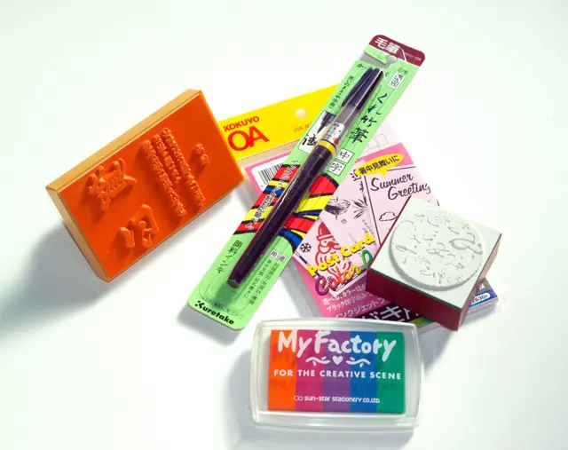 Blank postcards, rubber stamps, and a brush for preparing nengajō