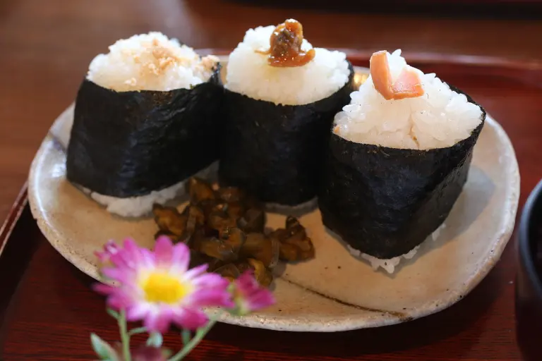 Plate of Japanese onigiri rice balls with nori and side dishes