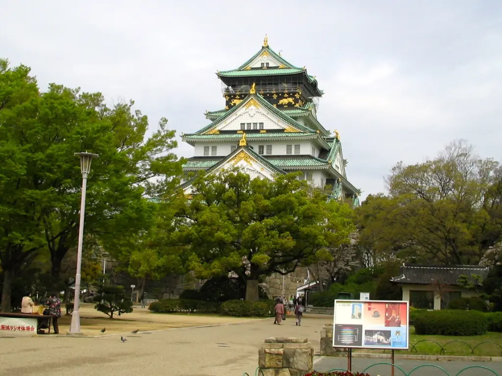 Osaka Castle above stone ramparts, trees, and water