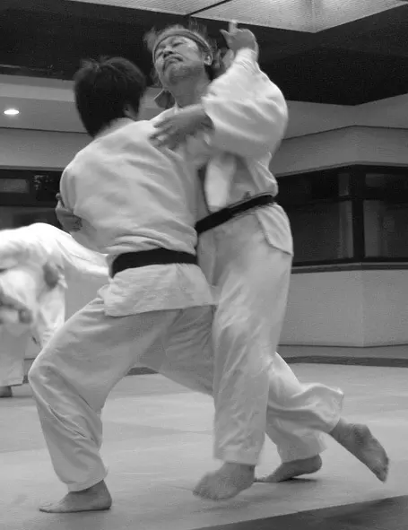 Two judoka demonstrate o-uchi-gari in a dojo