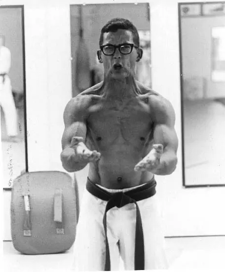 Karate practitioner performing a Sanchin posture indoors
