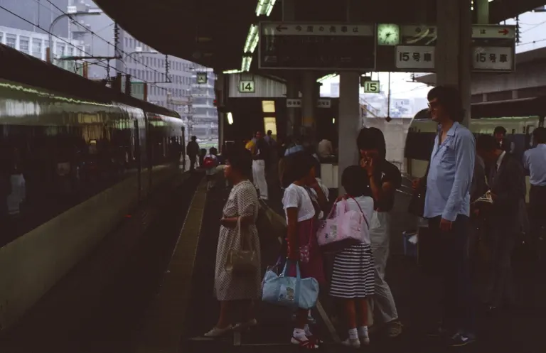 Passengers queue at marked door positions on a Shinkansen platform at Tokyo Station