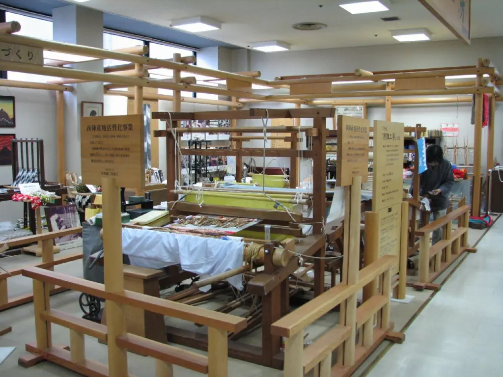 Rows of treadle looms inside the Nishijin Textile Center in Kyoto
