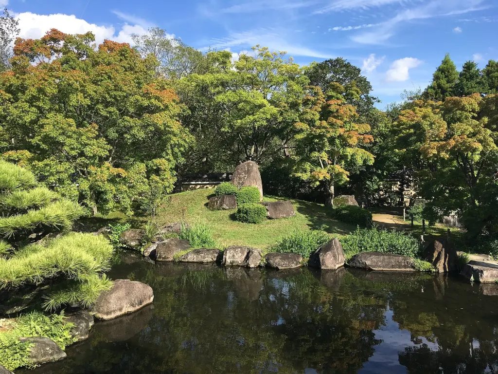 Pond, stones, trees, and constructed slopes in Kōko-en's Tsukiyama Chisen Garden