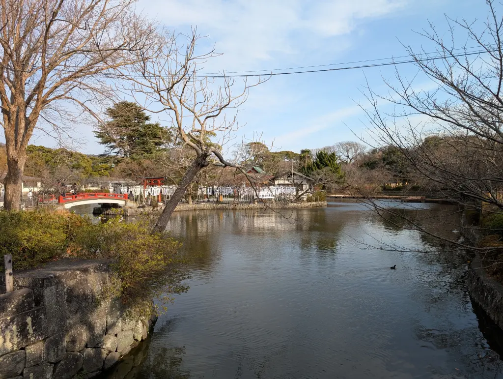 Genpei Pond at Tsurugaoka Hachimangū with a red bridge, leafless winter trees, and an island shrine