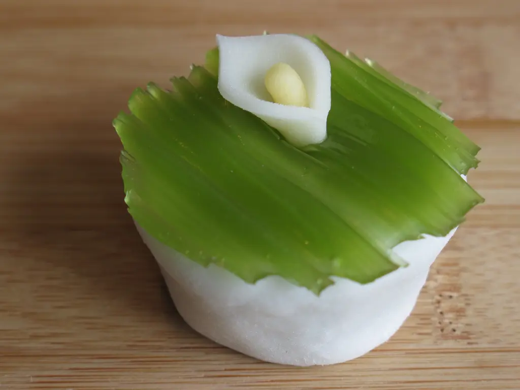 White and green Japanese sweet shaped like a mizubashō flower.