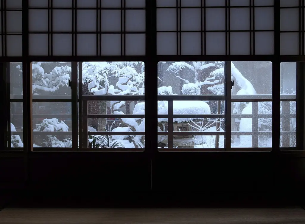Yukimi shoji screens framing a view of a snowy Japanese garden