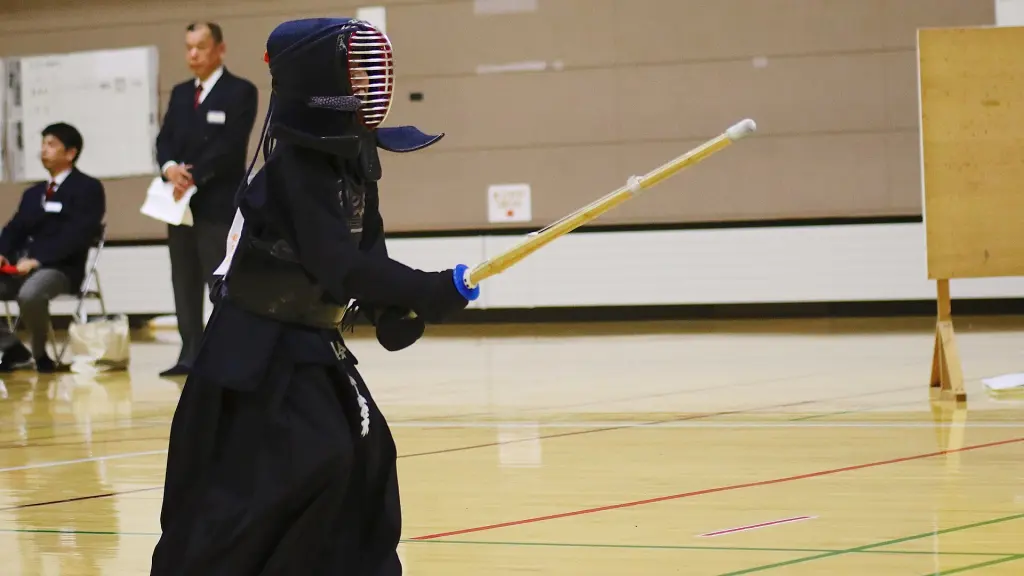 Two Kendo competitors wearing bogu and holding shinai in a tournament hall