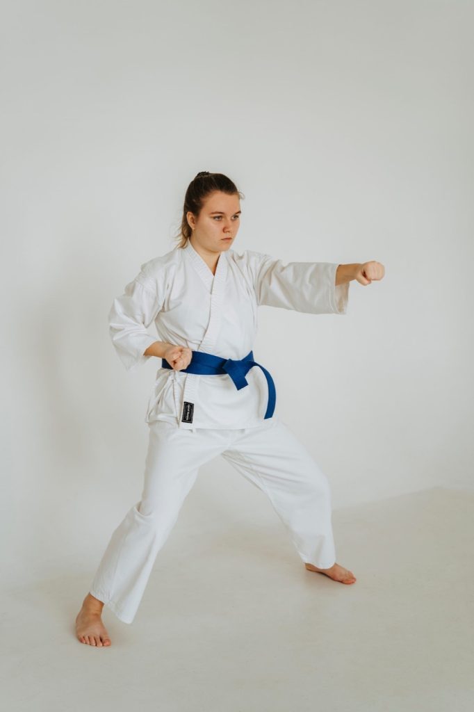 A karate practitioner in a white gi performing a kata stance